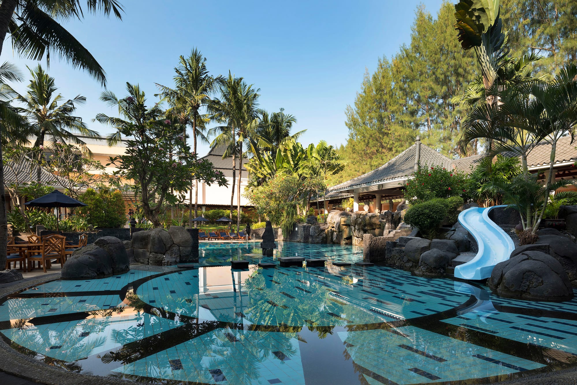 a pool with a slide and trees