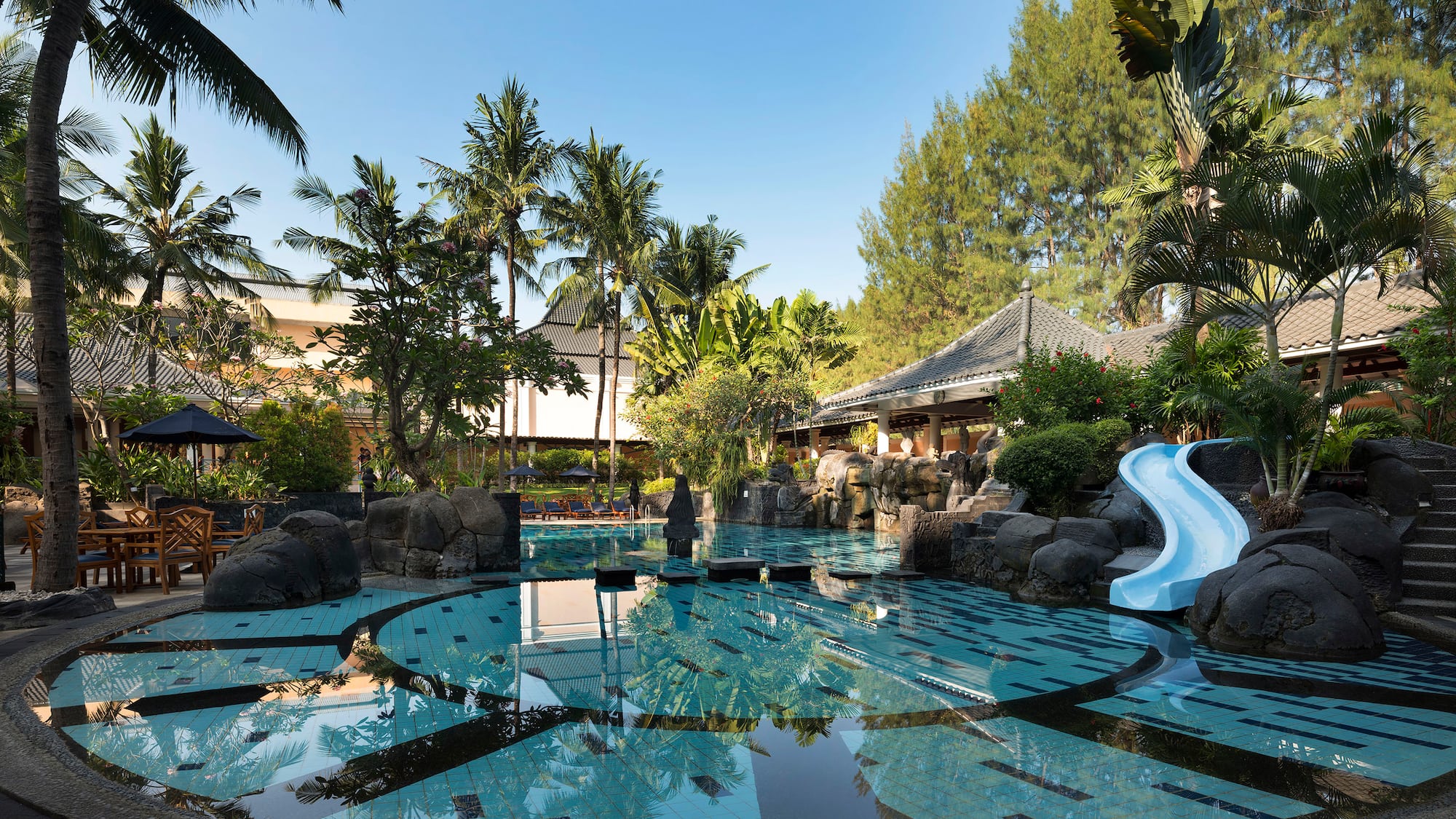 a pool with a slide and trees