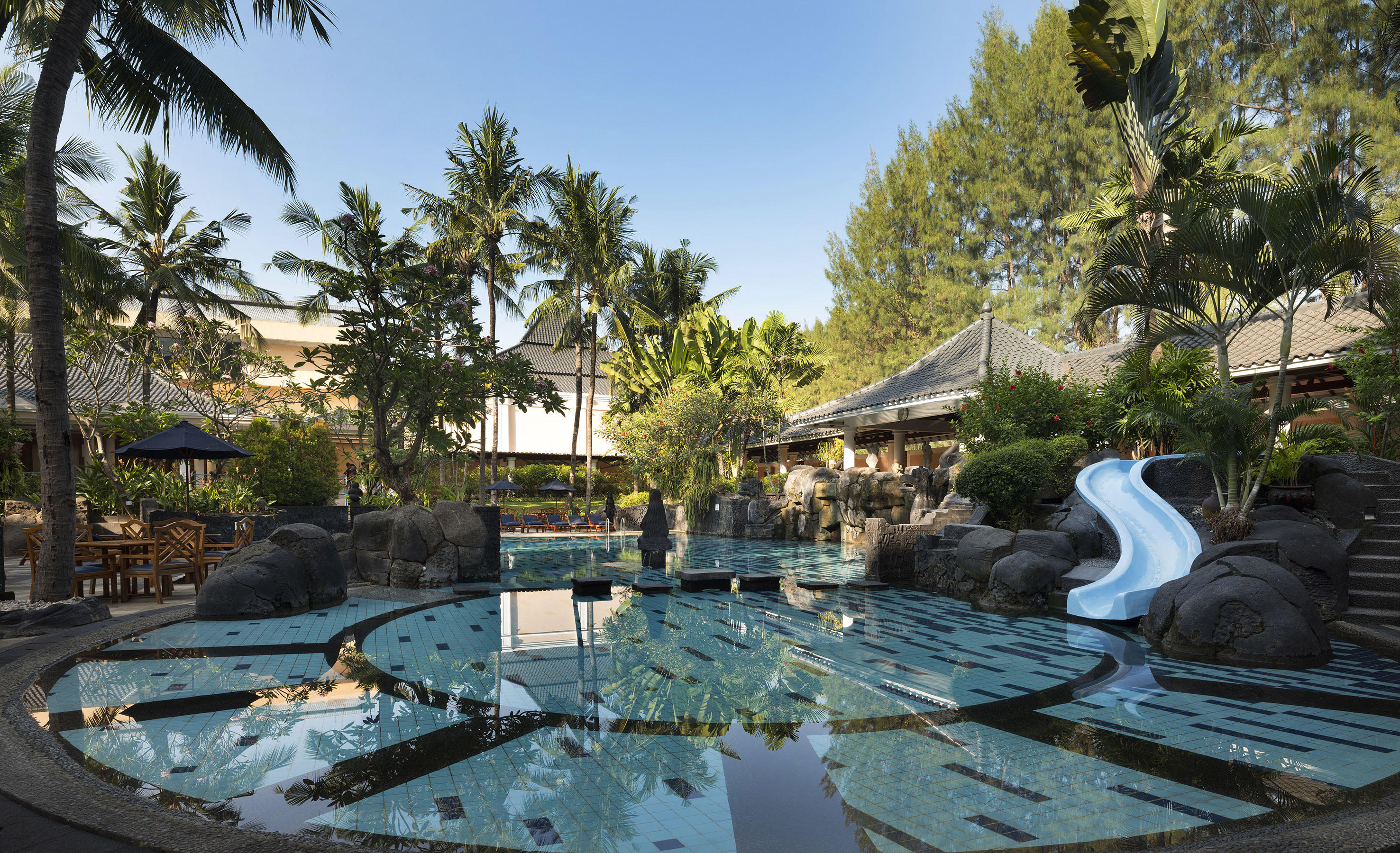 a pool with a slide and trees