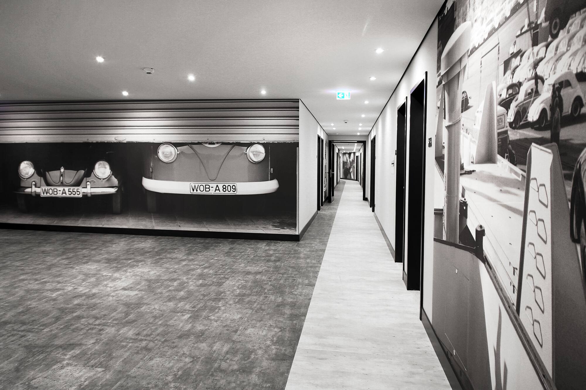 Black and white hallway with classic Volkswagen car murals.