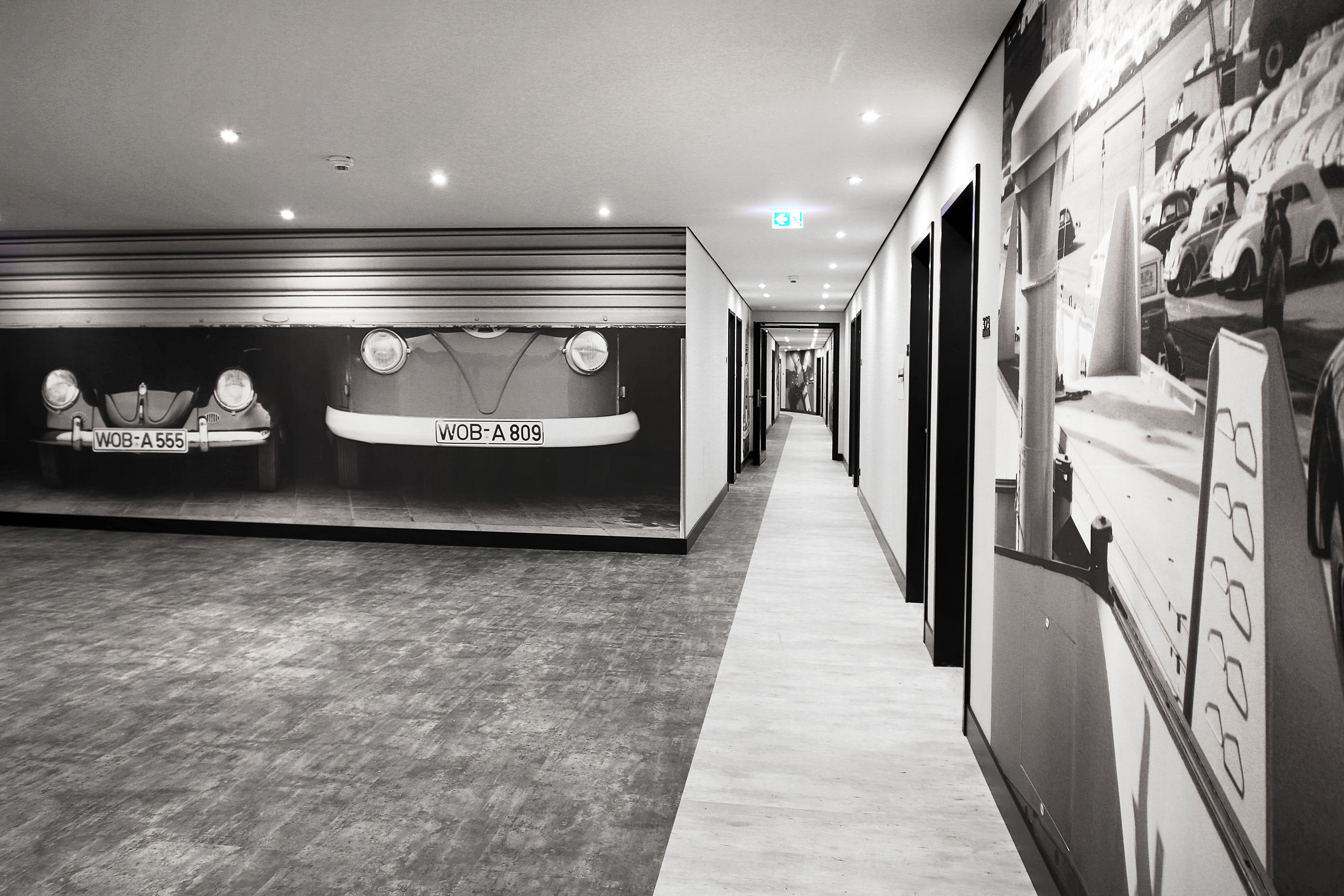 Black and white hallway with classic Volkswagen car murals.