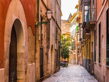 a narrow street with buildings and a bike on the side