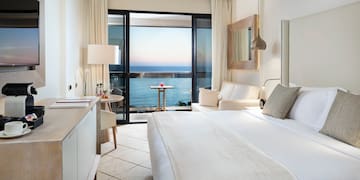 a room with a bed and a window overlooking the ocean