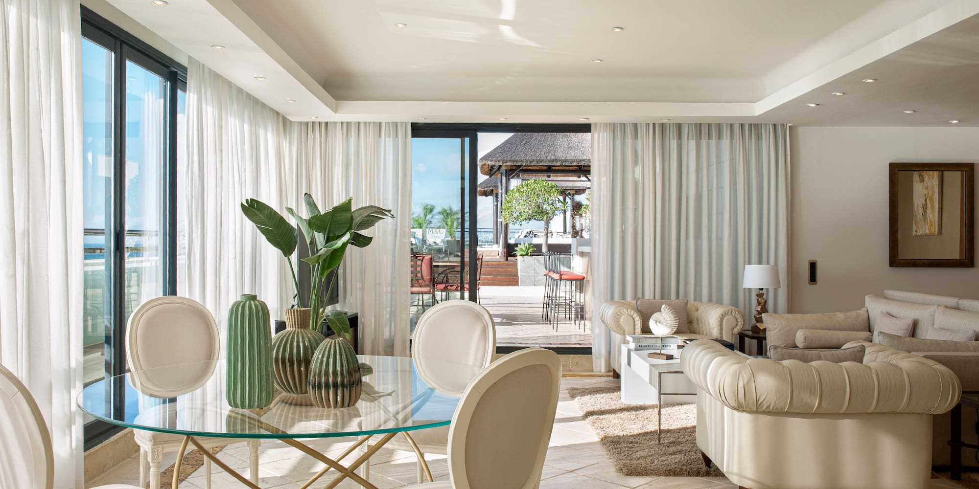 a living room with a glass table and chairs