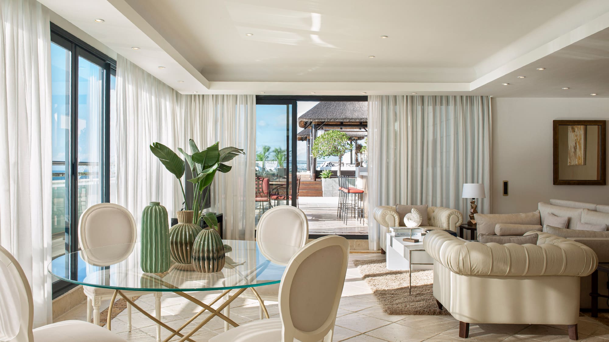 a living room with a glass table and chairs