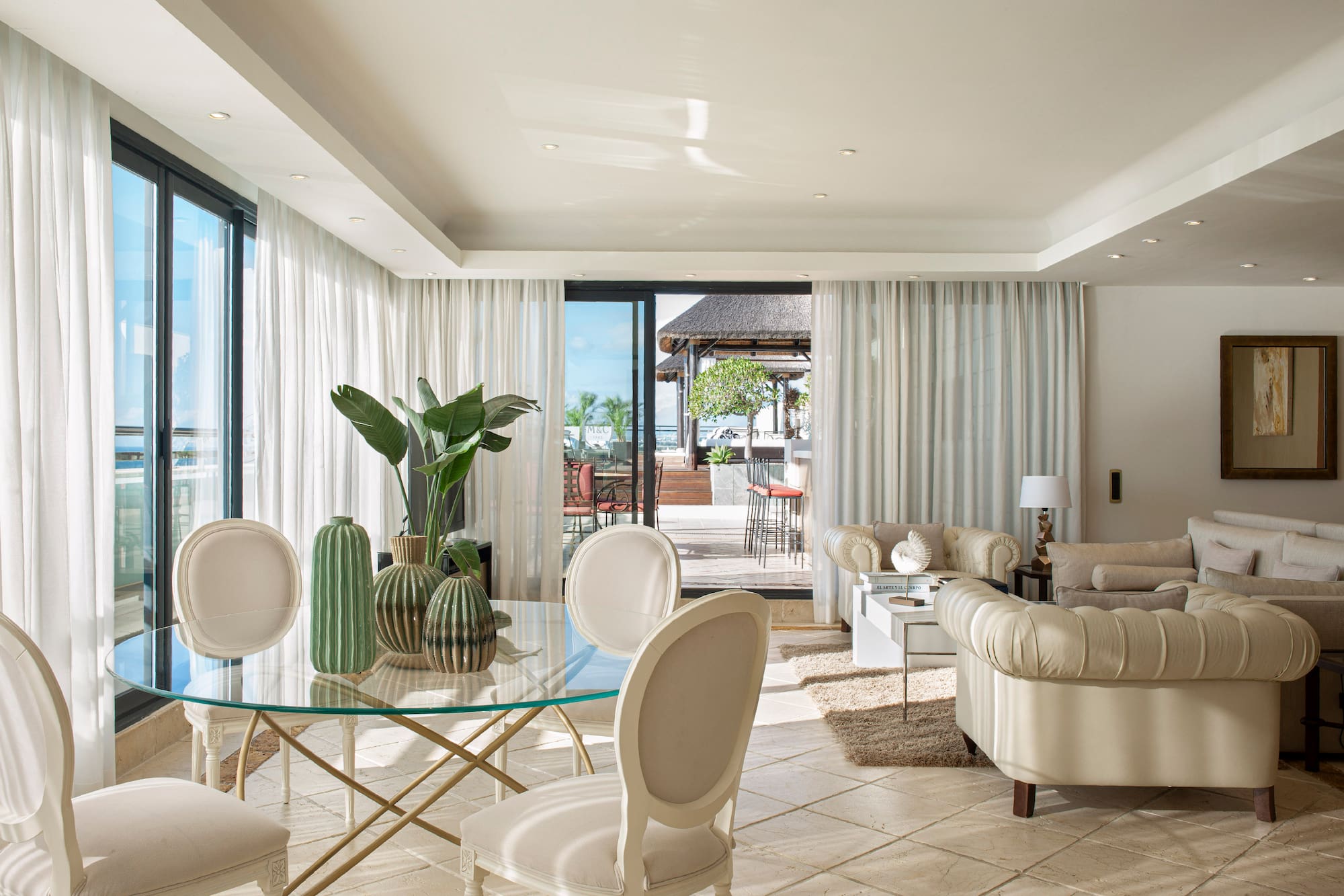 a living room with a glass table and chairs