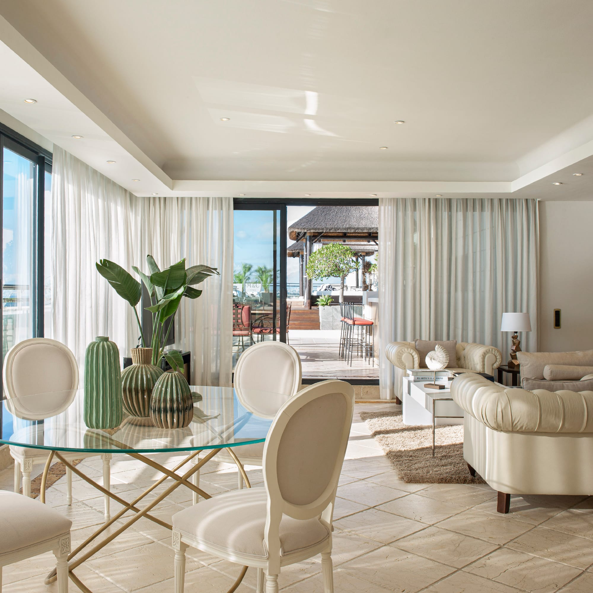a living room with a glass table and chairs