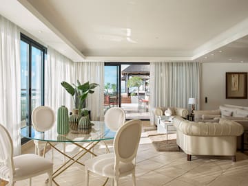 a living room with a glass table and chairs