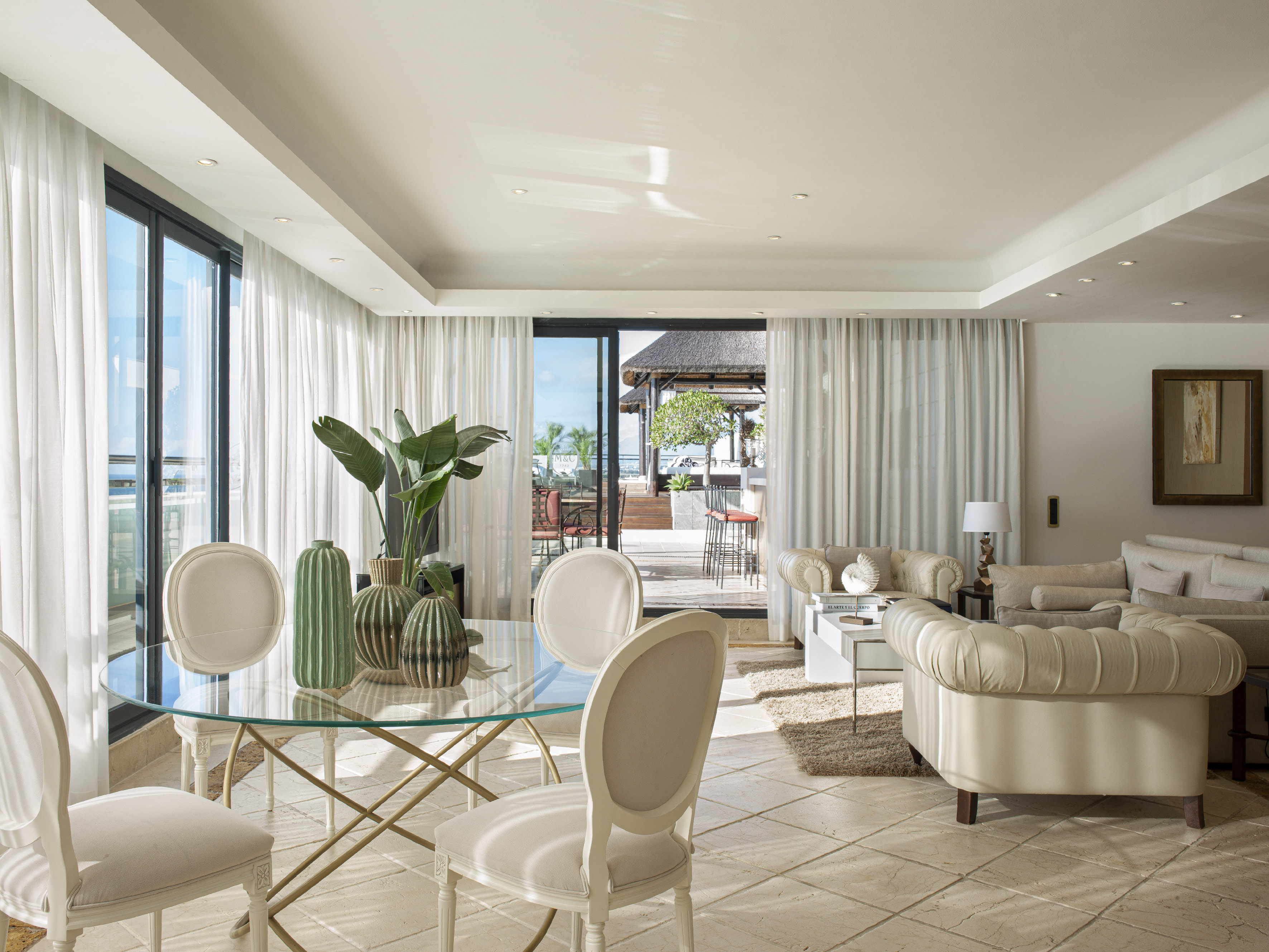 a living room with a glass table and chairs