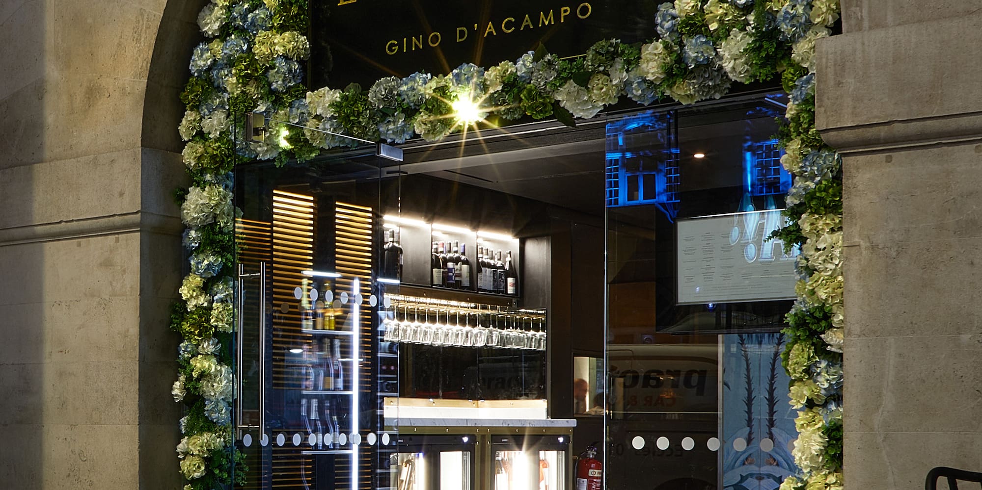 a building with a sign and flowers on it