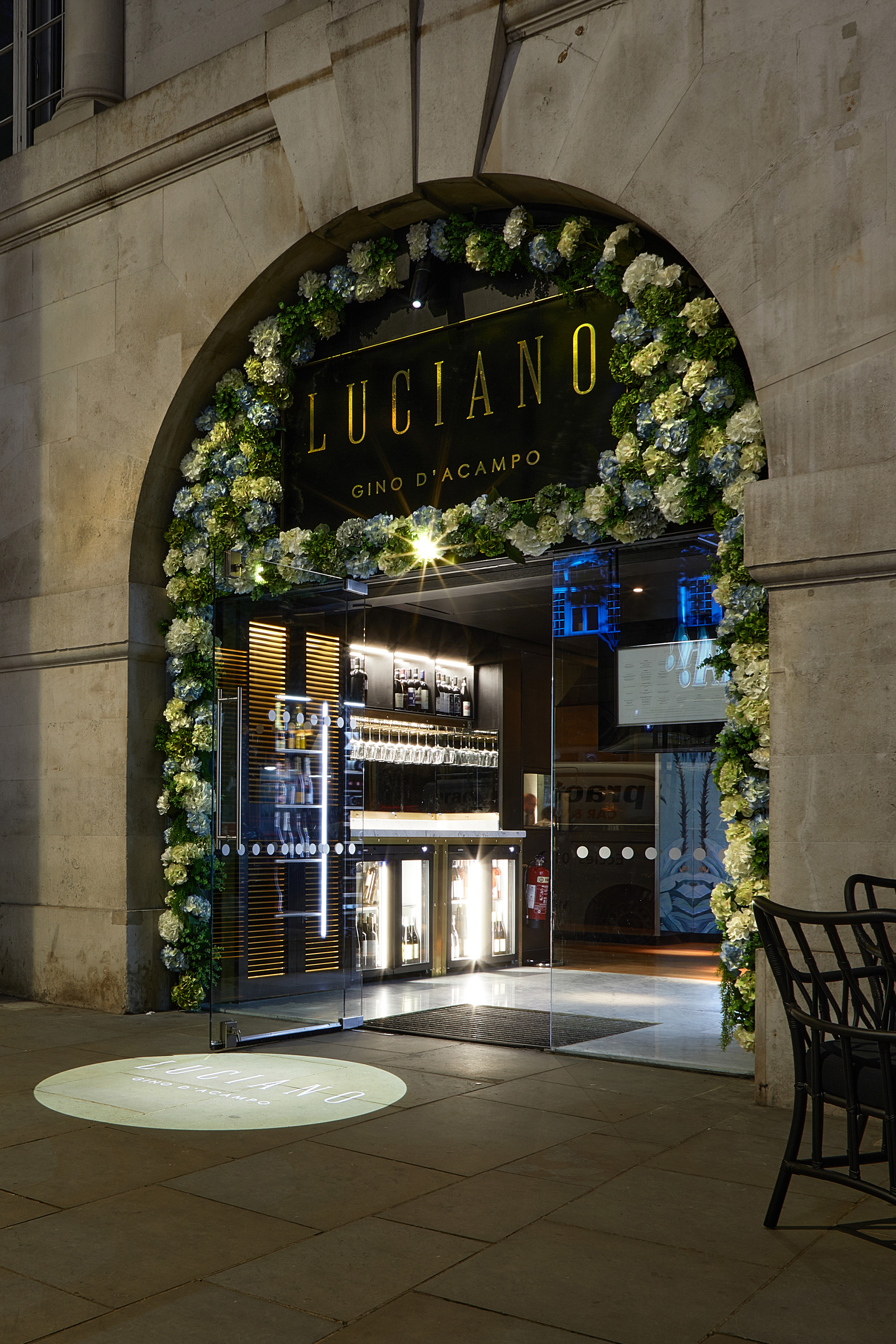 Luciano Gino D'Acampo restaurant entrance, floral archway, illuminated sign.