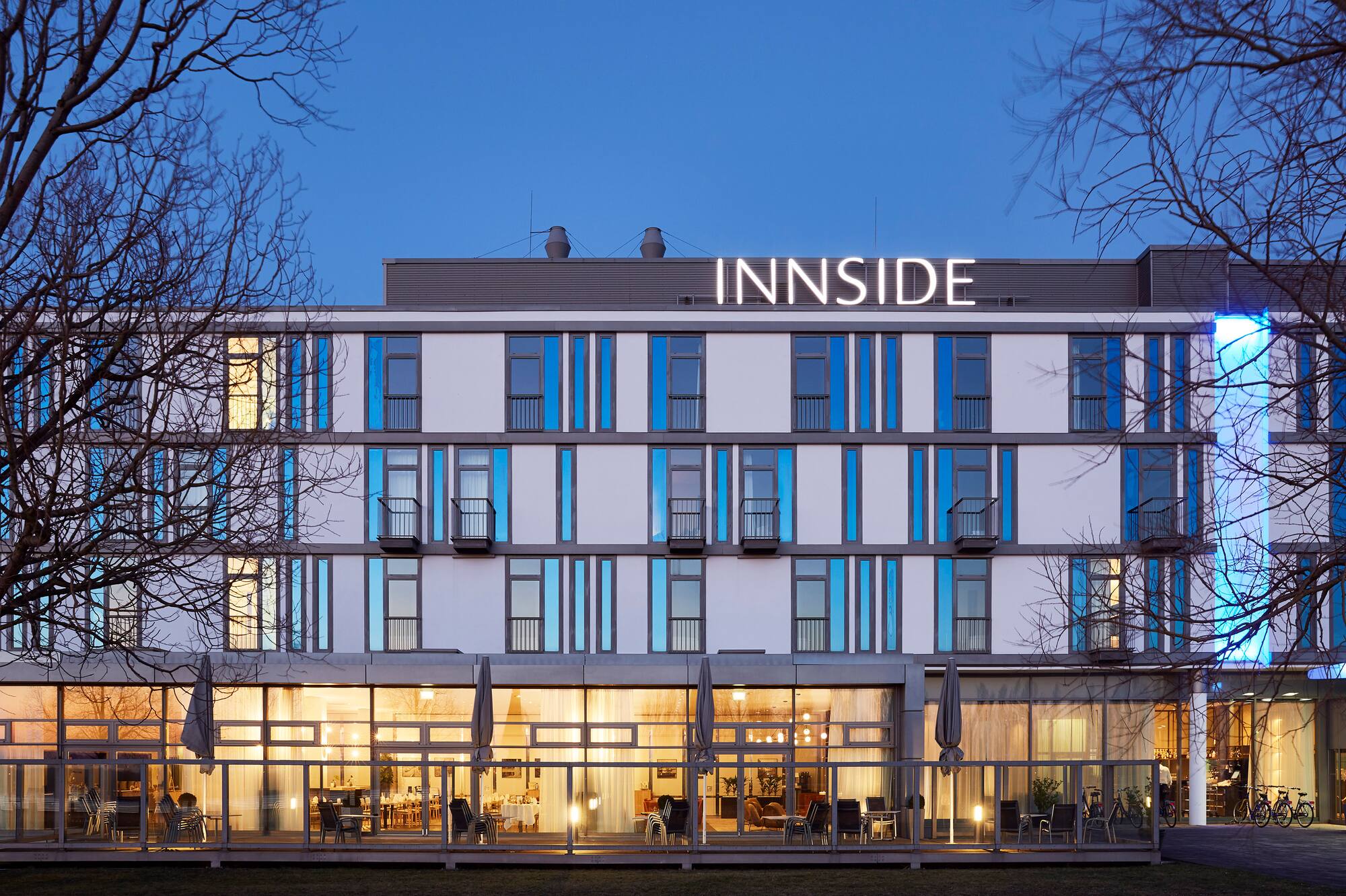 INNSIDE hotel exterior at night, illuminated modern building with blue accents.