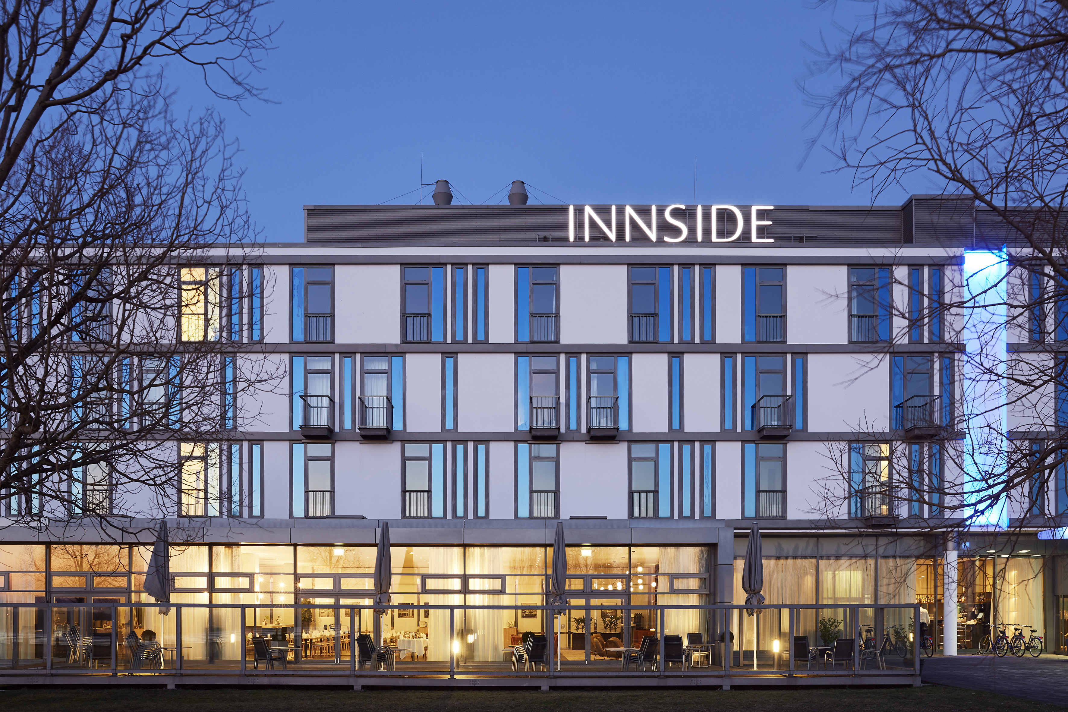 INNSIDE hotel exterior at night, illuminated modern building with blue accents.