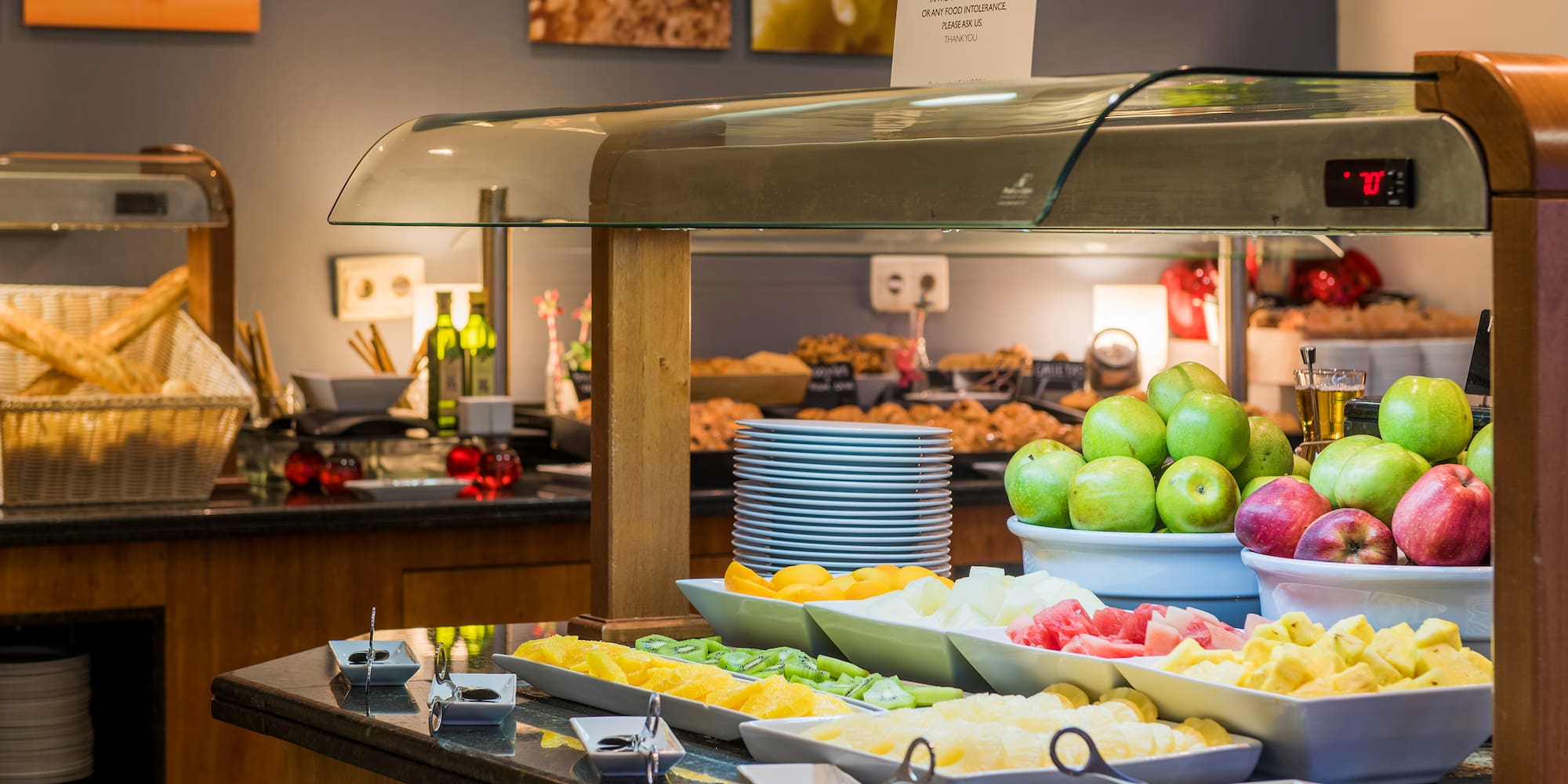 a buffet table with fruit and plates of food