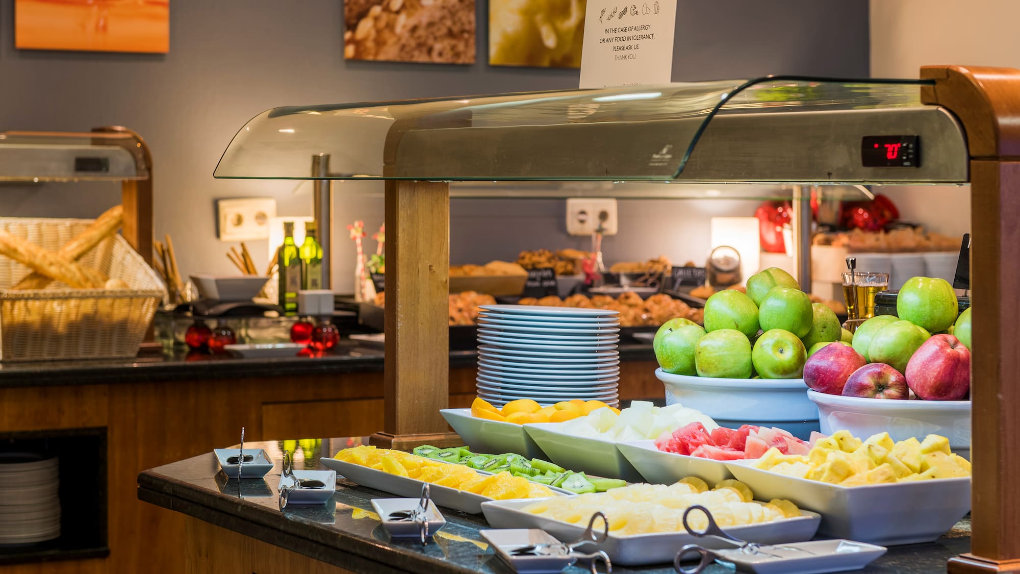 a buffet table with fruit and plates of food