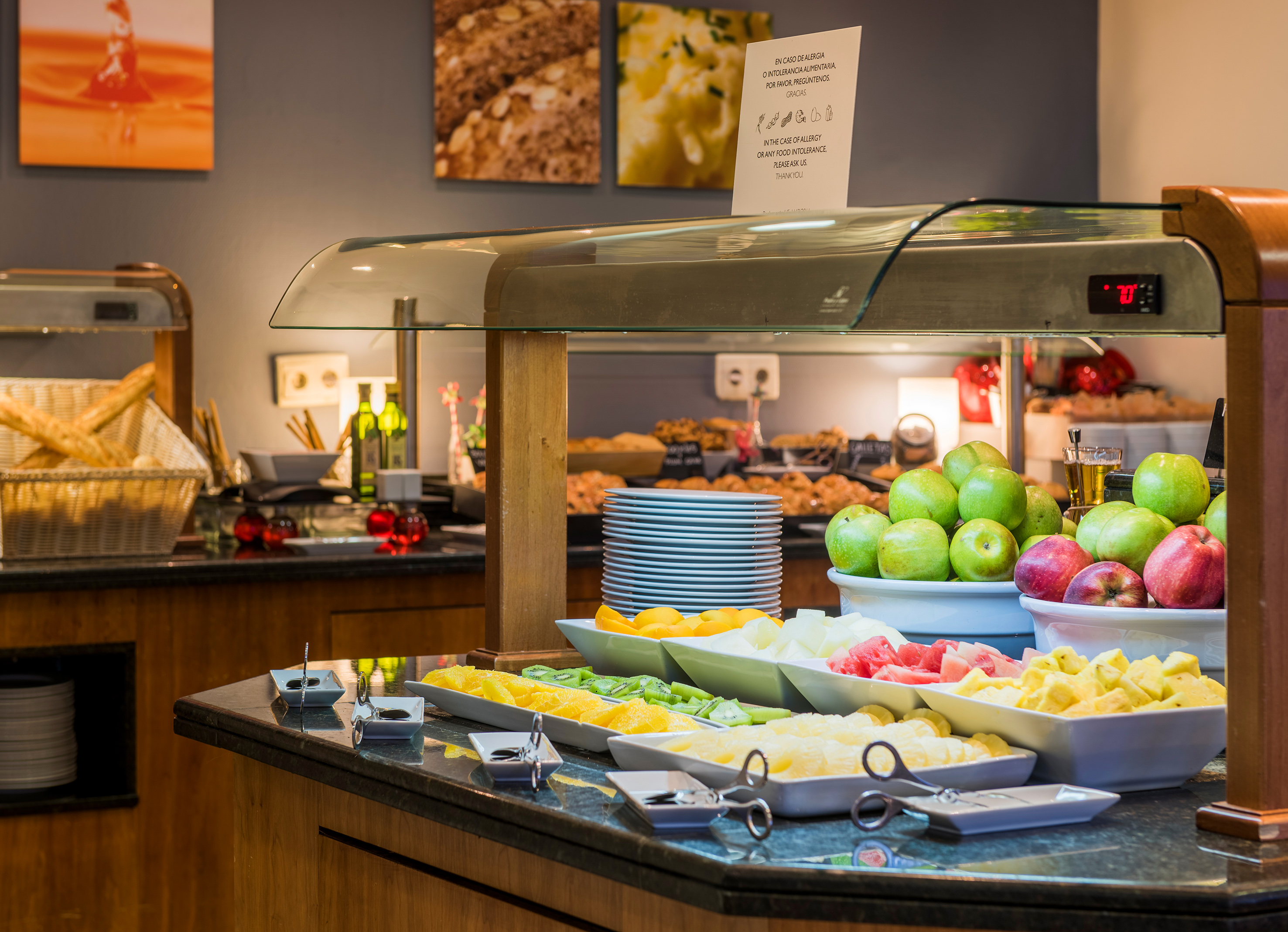 a buffet table with fruit and plates of food