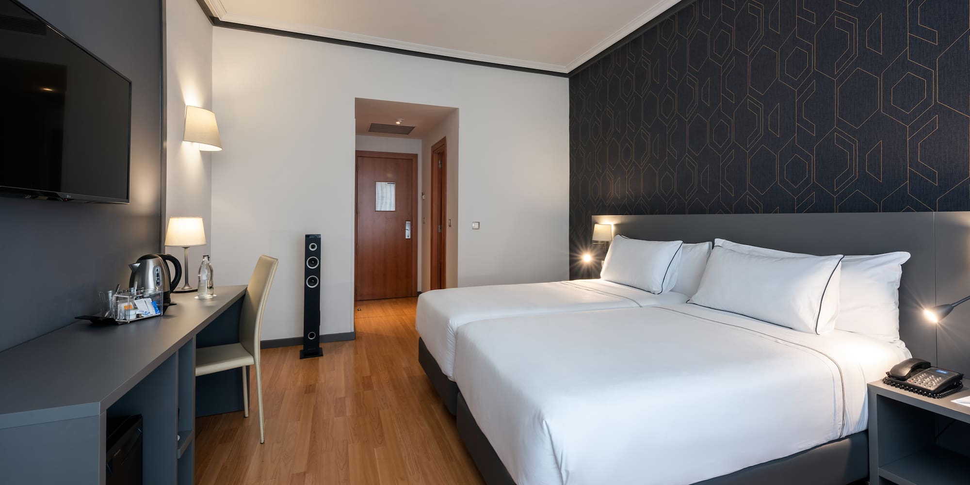 a room with two beds and a desk