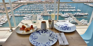a table with plates and glasses on it and a view of a marina