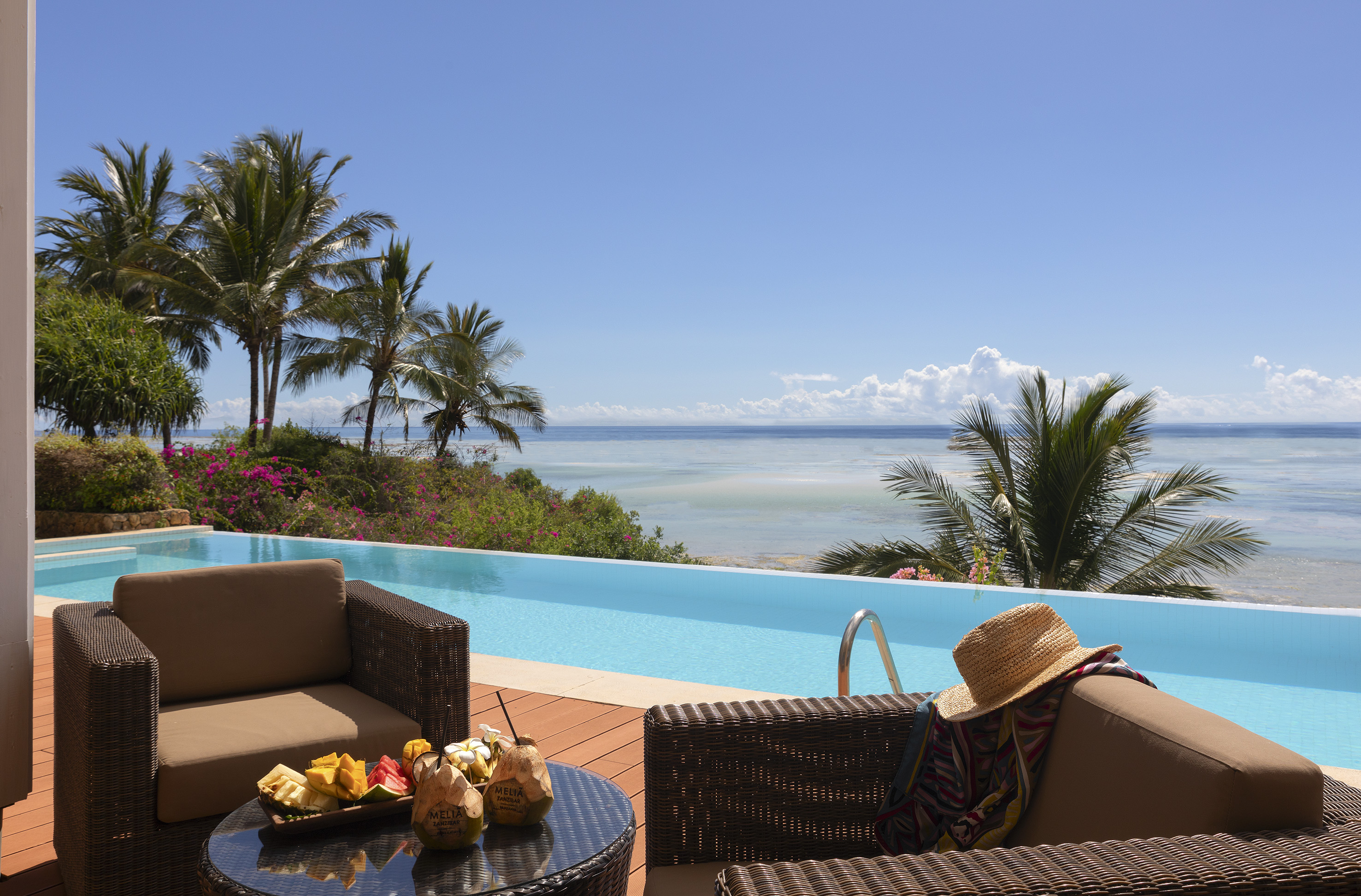a pool with a view of the ocean and a beach