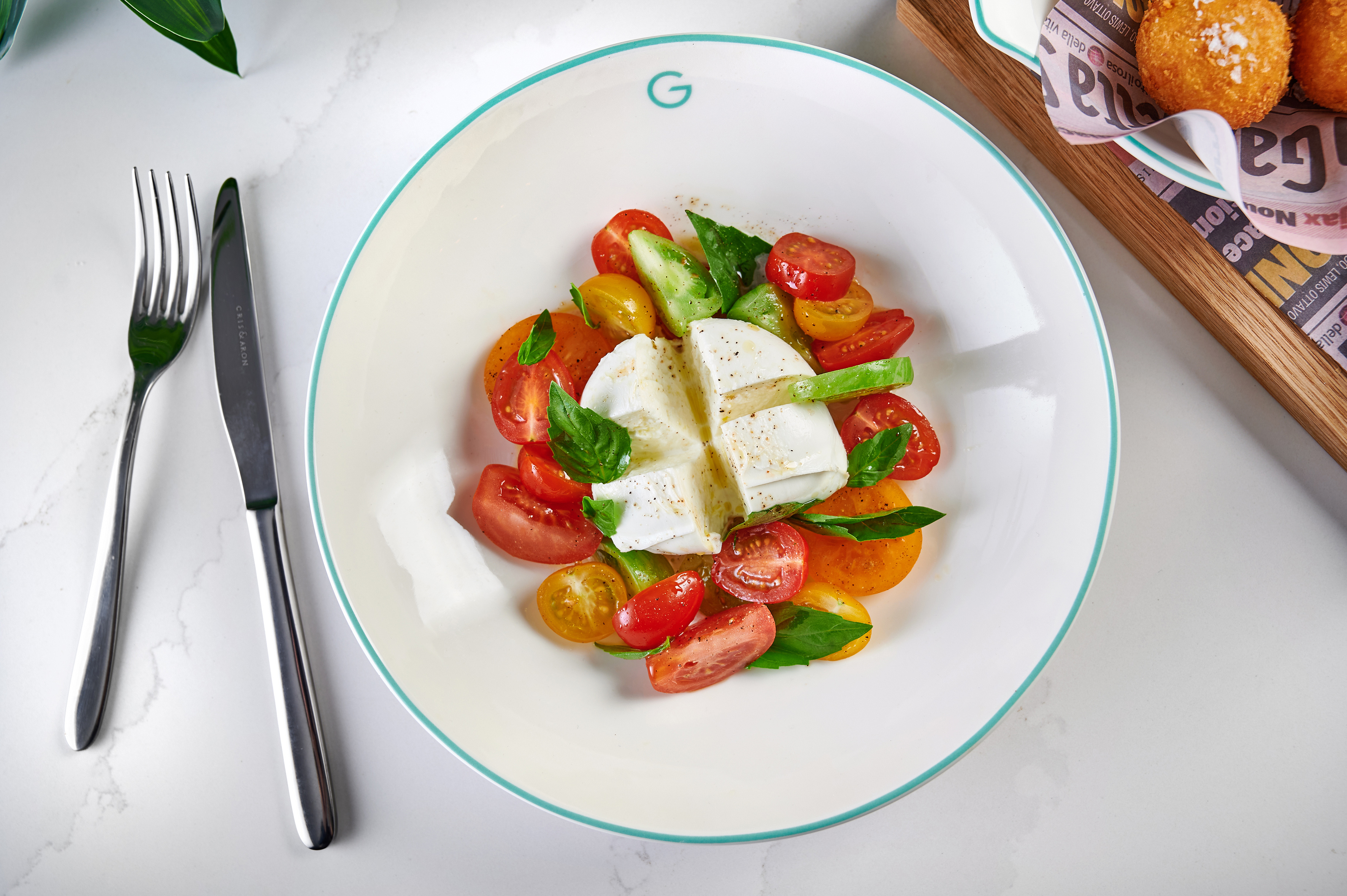 Caprese salad with burrata cheese, colorful cherry tomatoes, fresh basil.