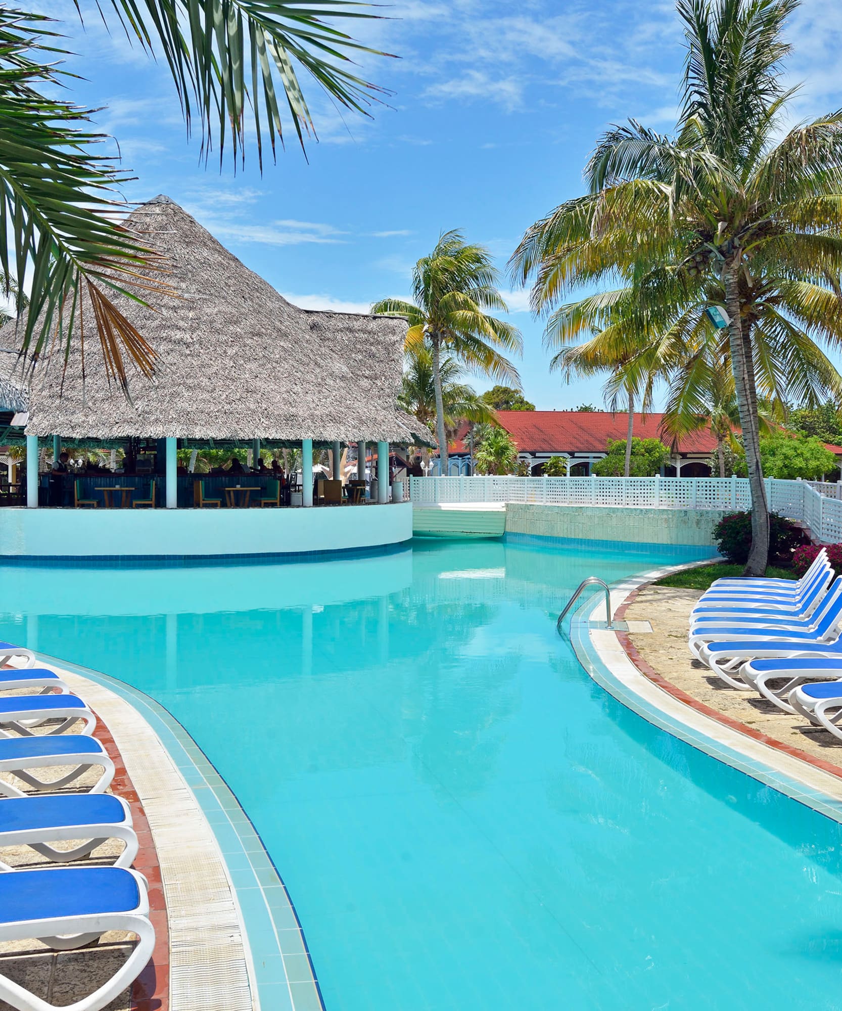 a pool with lounge chairs and a bar
