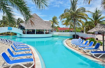 a pool with lounge chairs and a bar