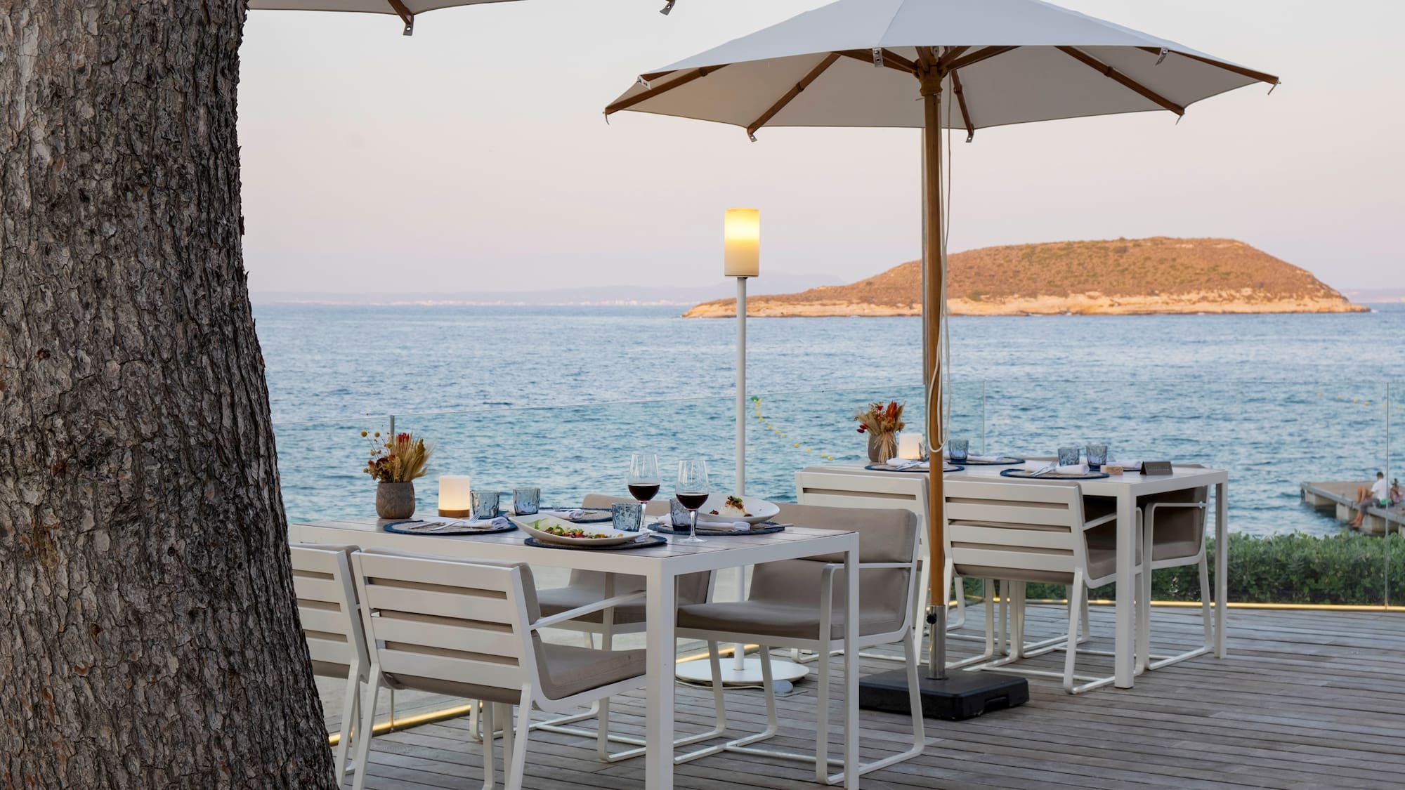 a table and chairs on a deck overlooking a body of water