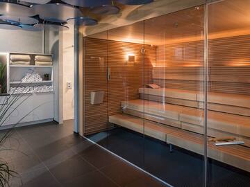 a sauna with glass walls and a glass door
