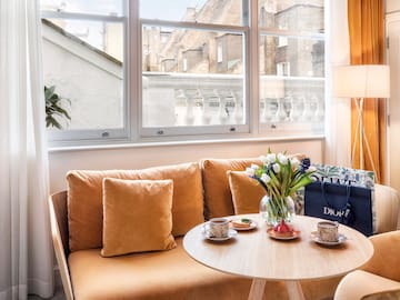 A couch with a coffee table and a bag resting on it.