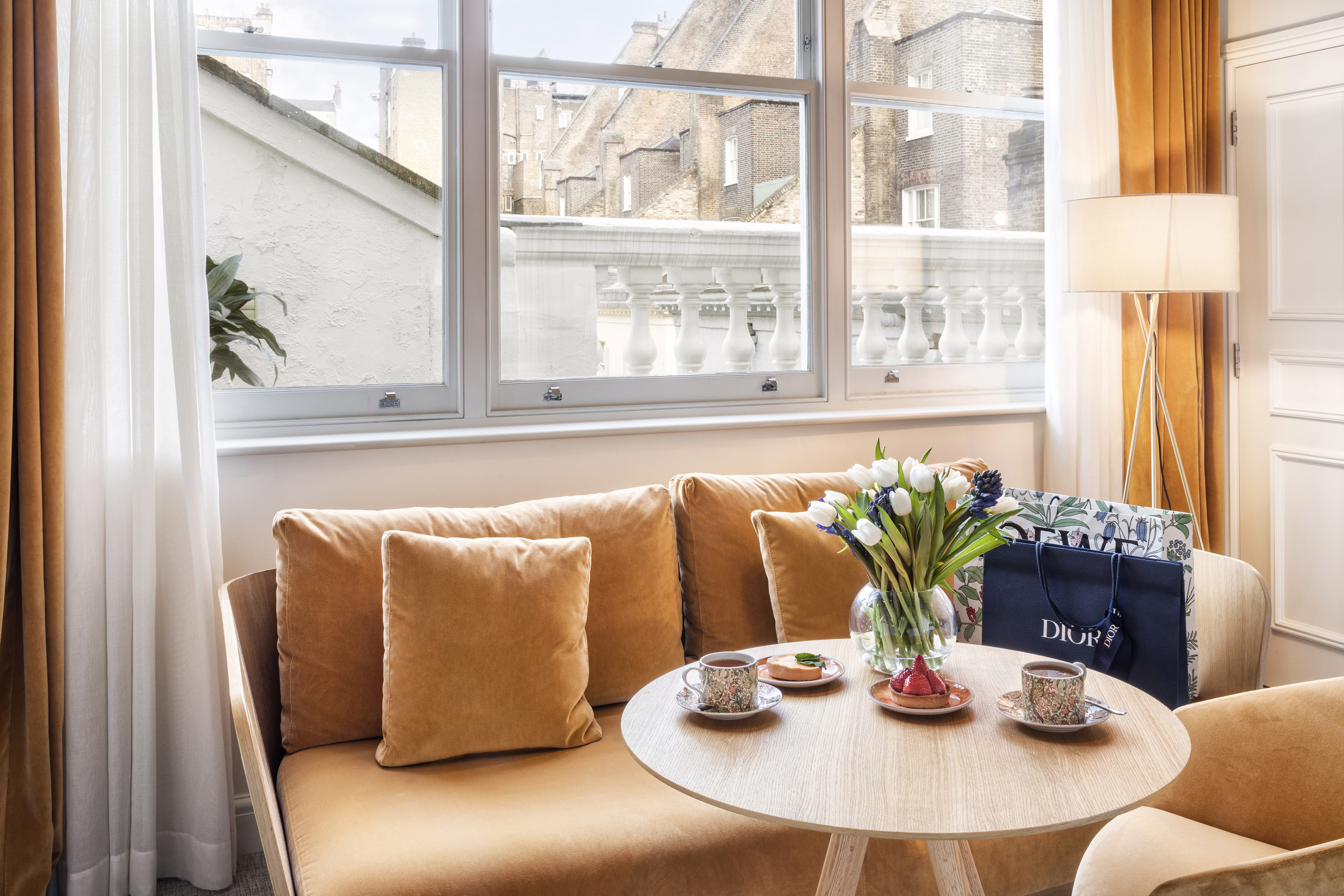 A couch with a coffee table and a bag resting on it.