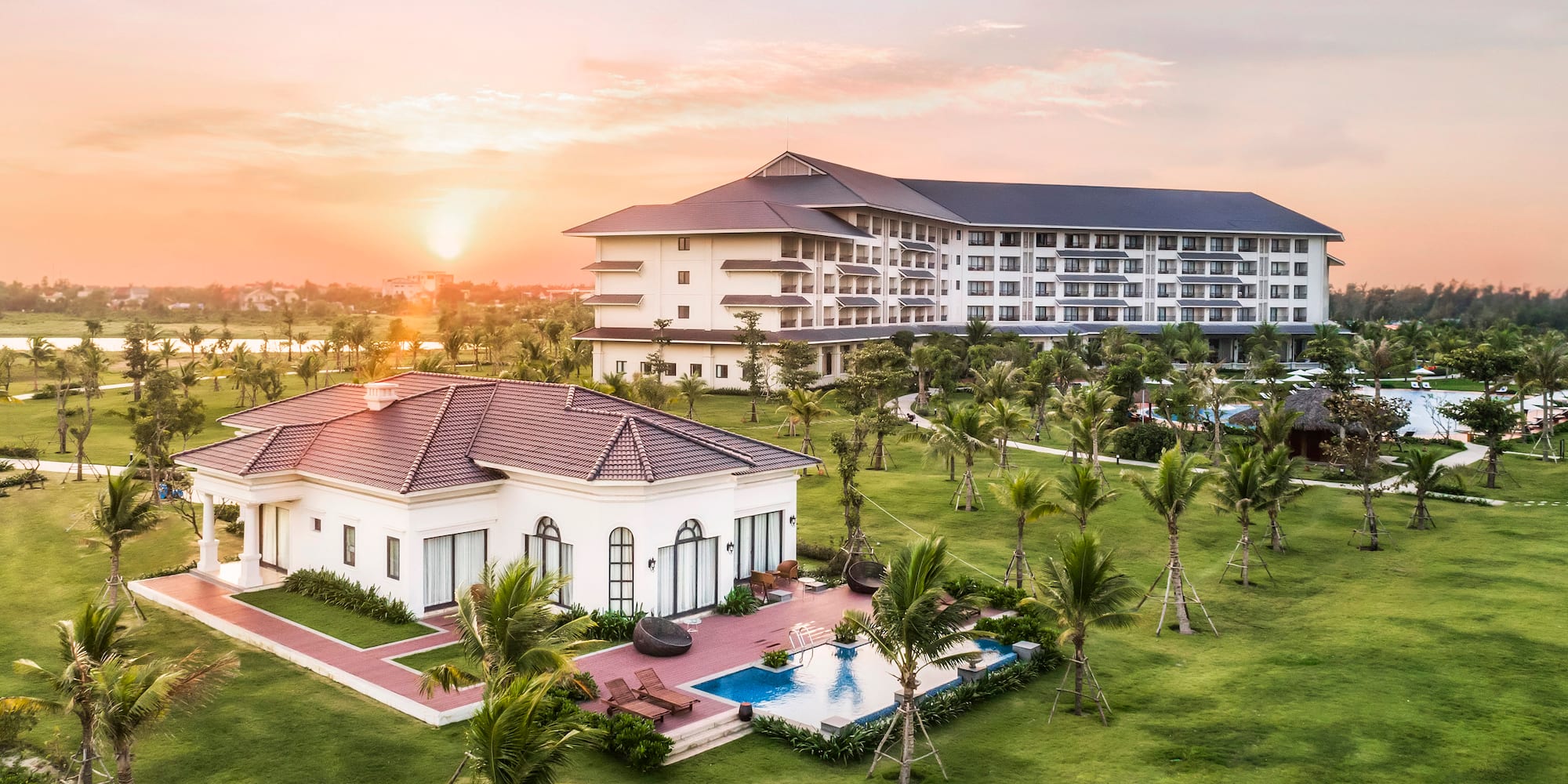 a building with a pool and palm trees