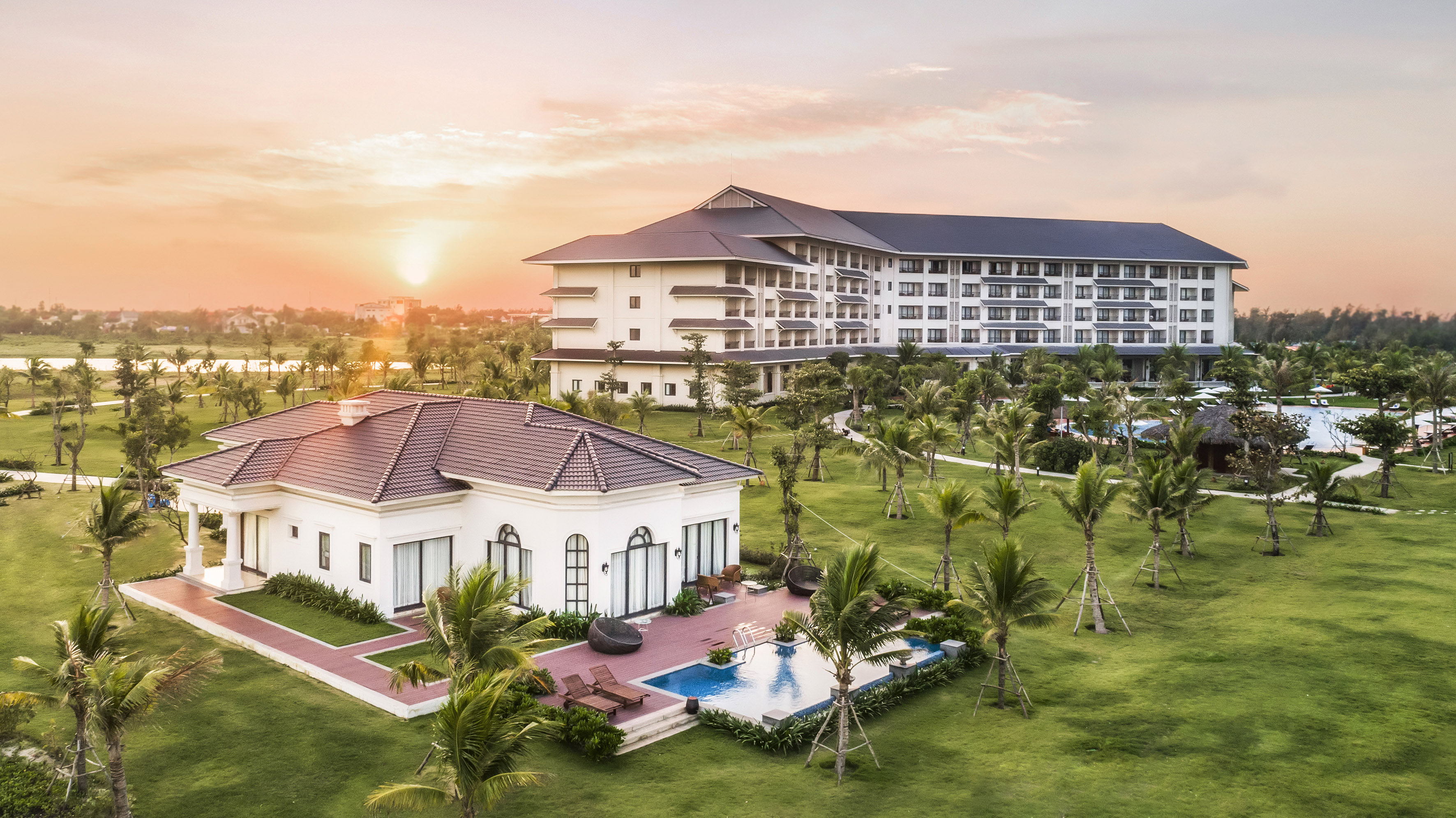 a building with a pool and palm trees