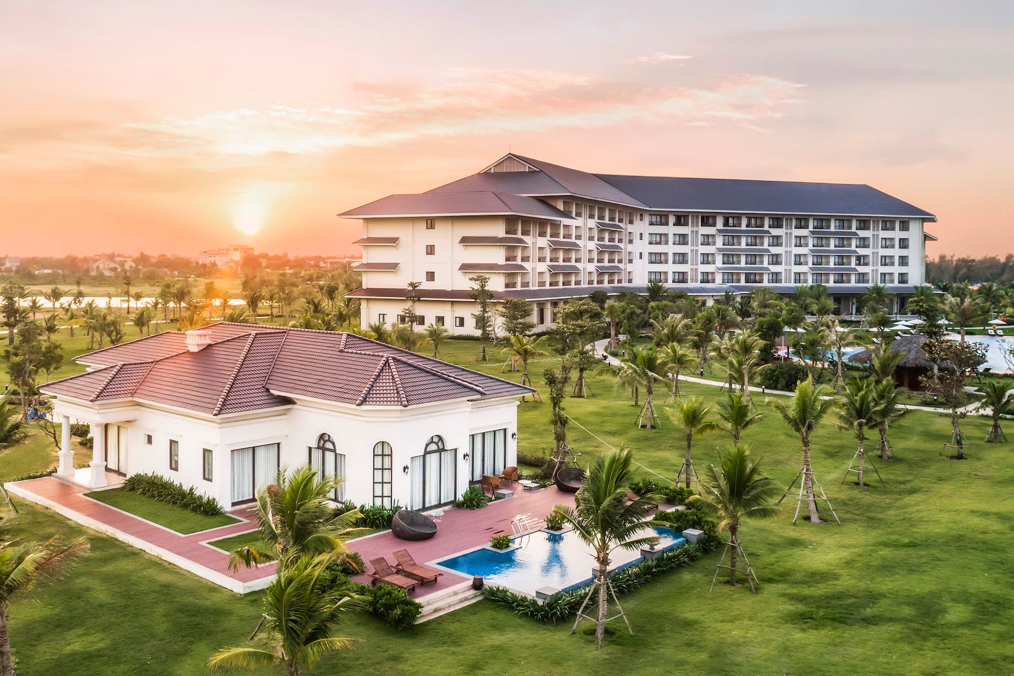 a building with a pool and palm trees