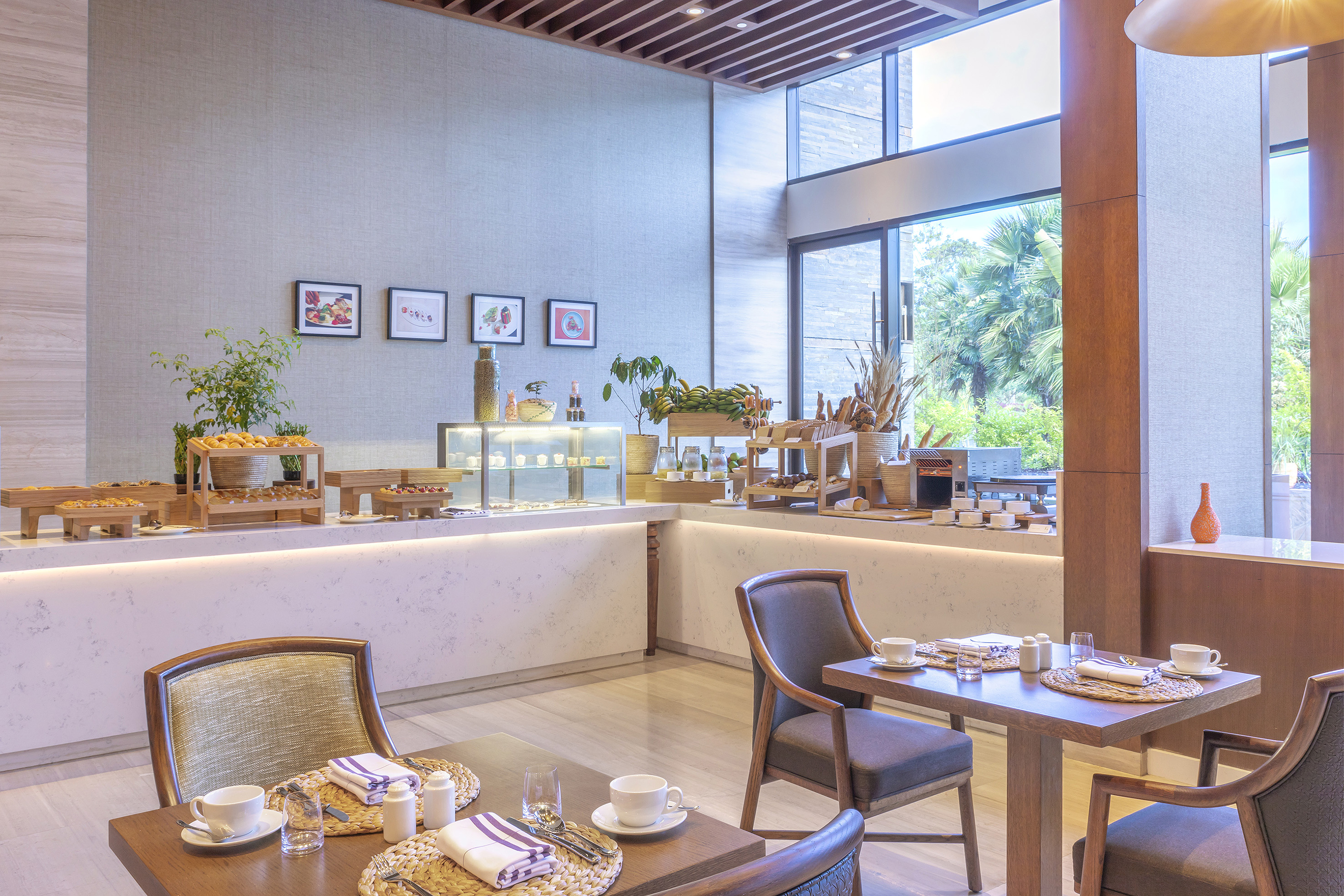 Modern hotel breakfast buffet with pastries, fruits, and contemporary dining tables.