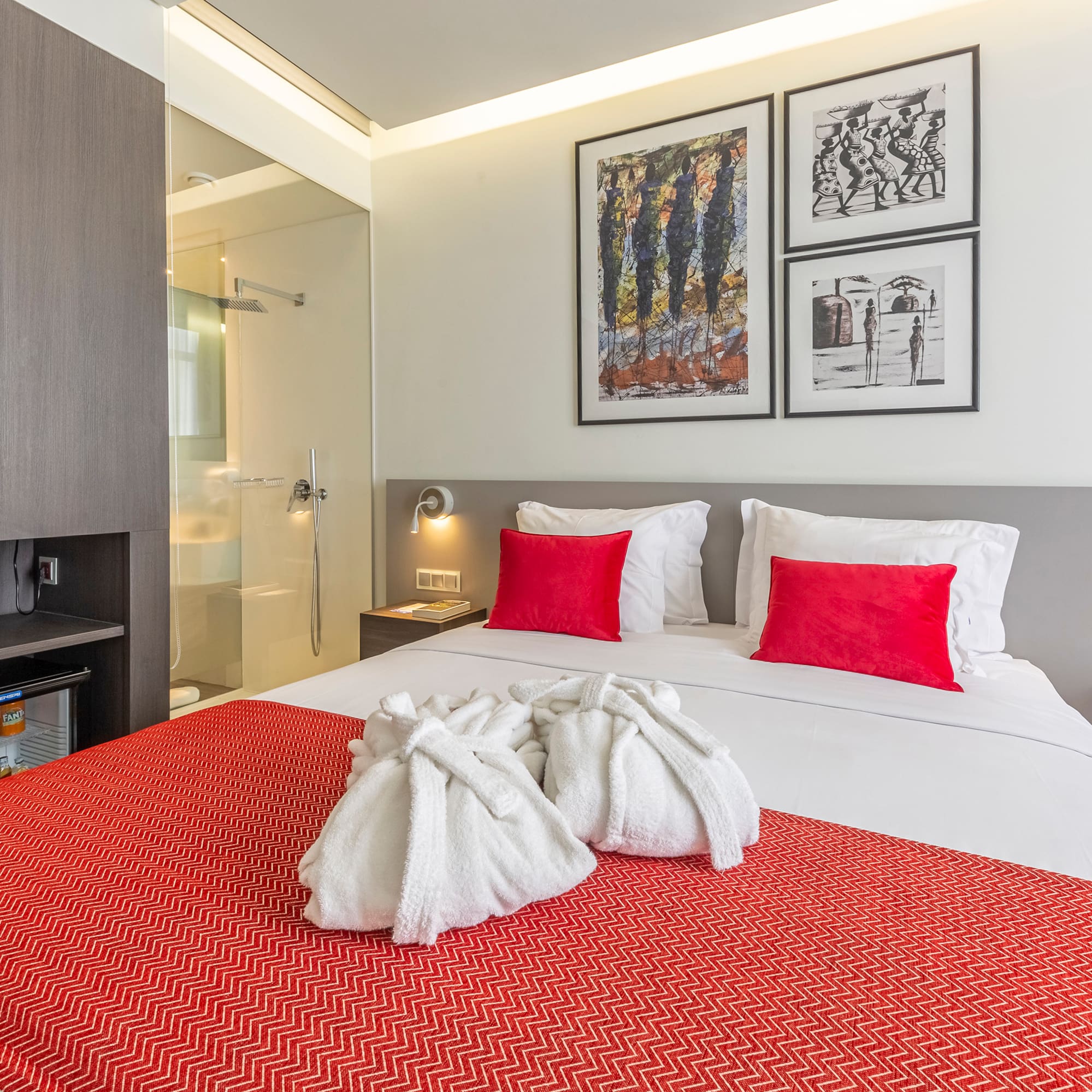 a bed with white towels and red pillows