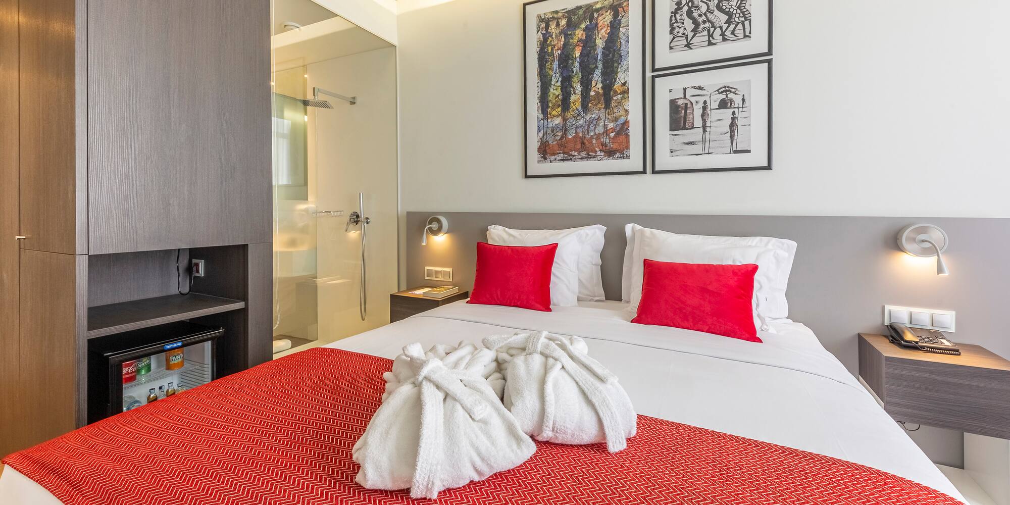 a bed with white towels and red pillows