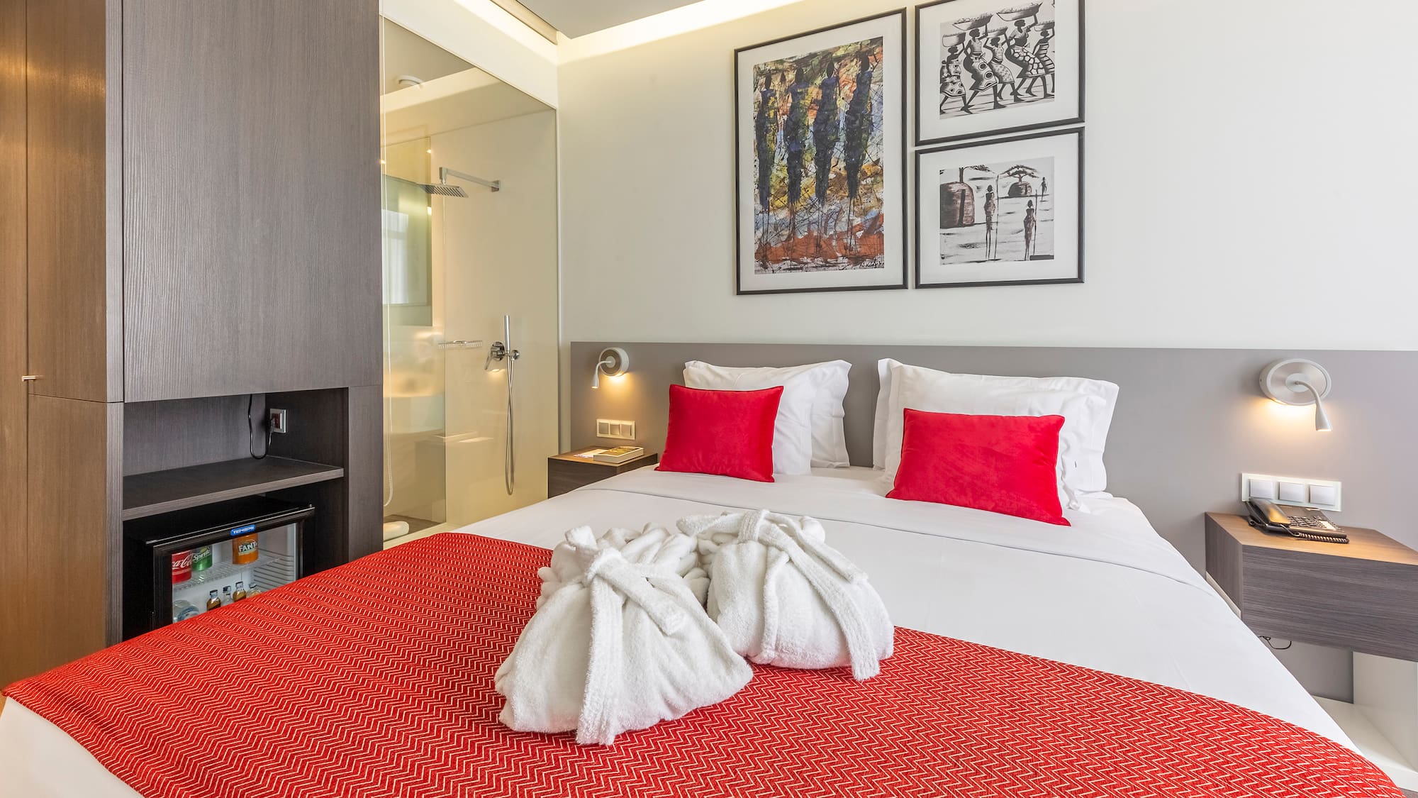 a bed with white towels and red pillows