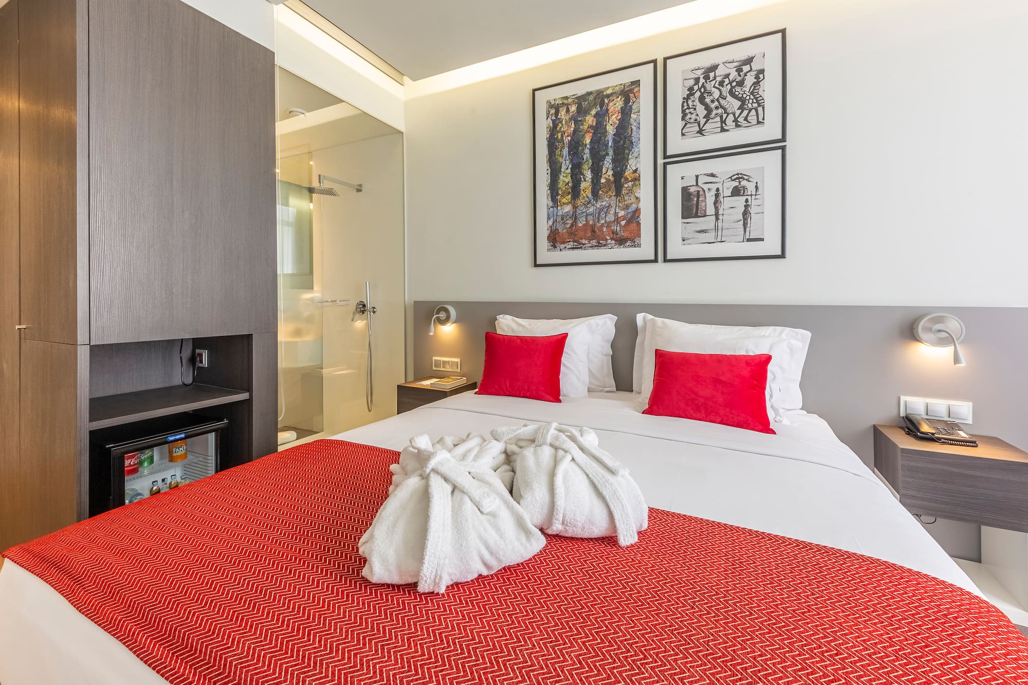 a bed with white towels and red pillows