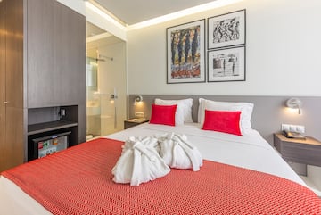 a bed with white towels and red pillows