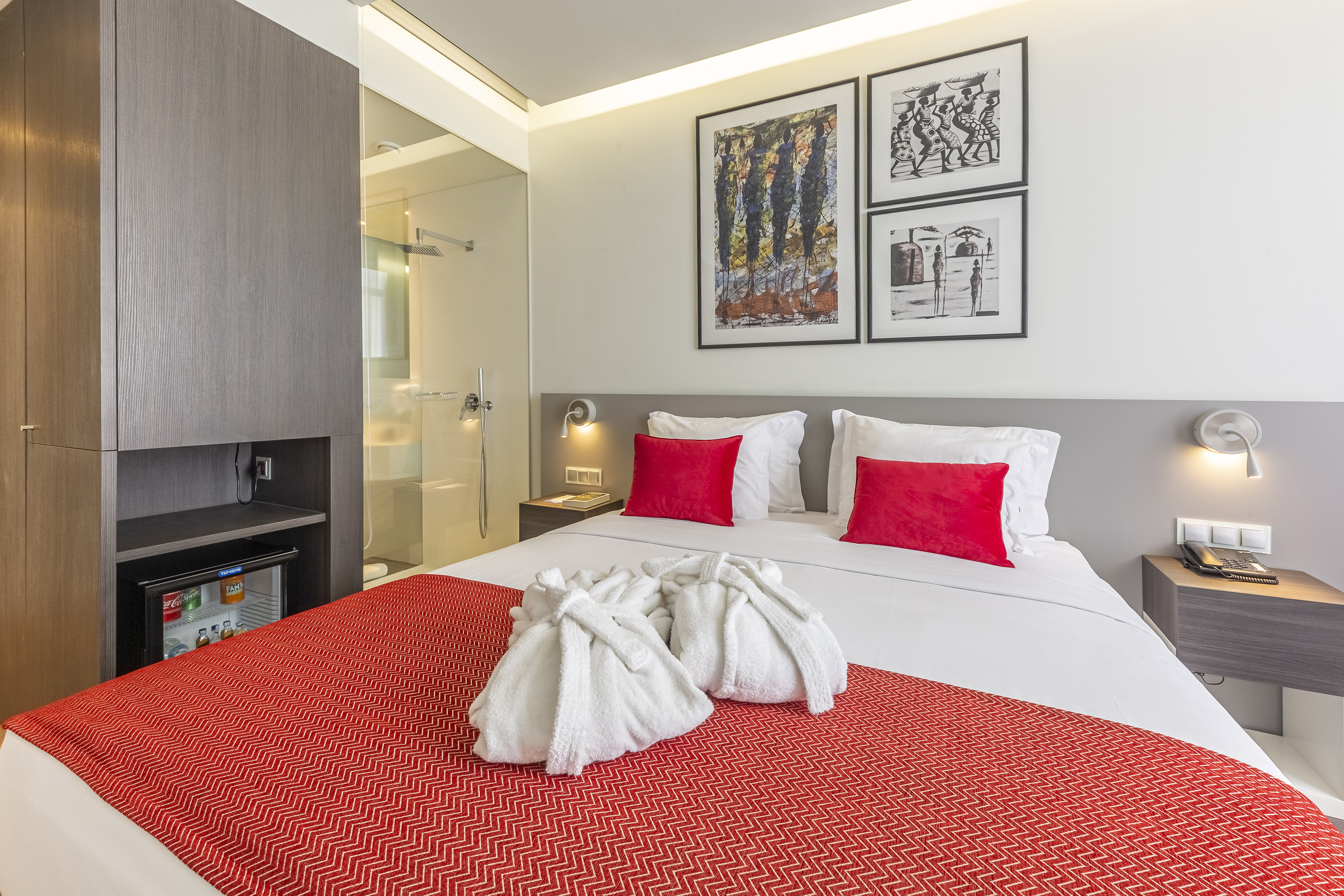 a bed with white towels and red pillows