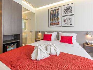 a bed with white towels and red pillows
