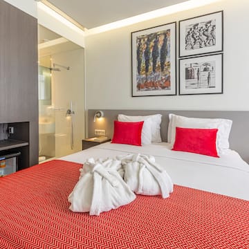 a bed with white towels and red pillows