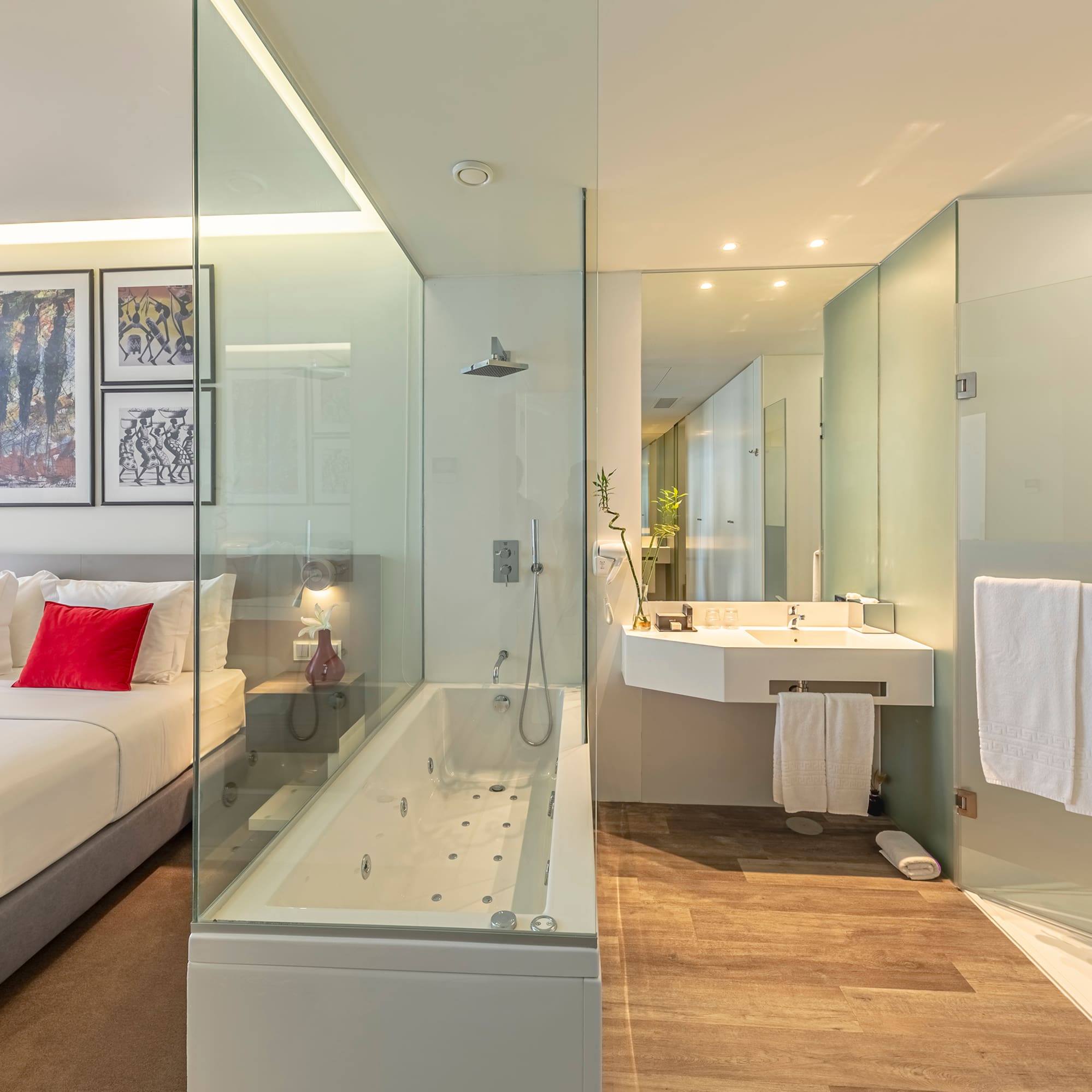 a bathroom with a glass shower and a bed
