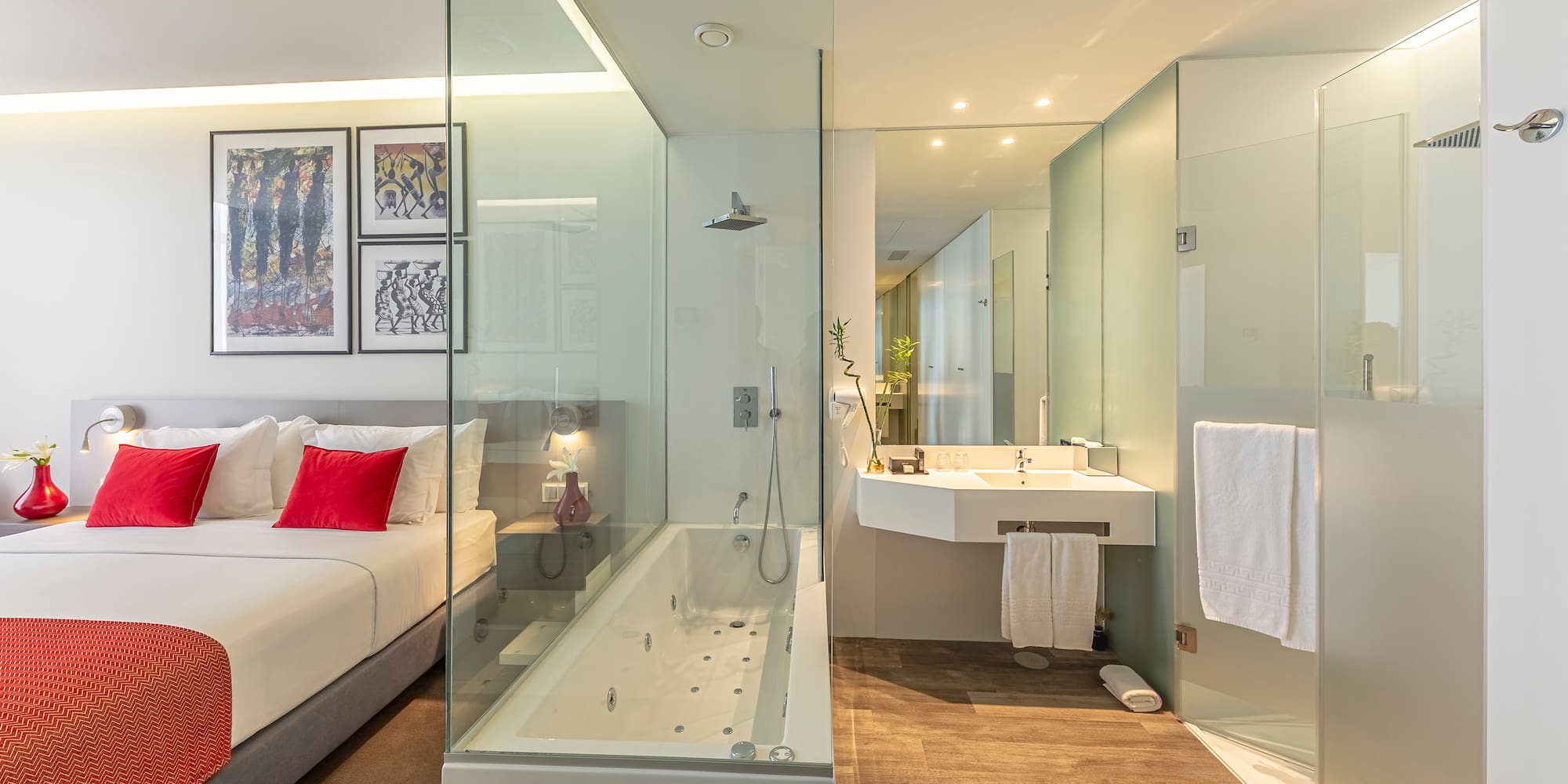 a bathroom with a glass shower and a bed