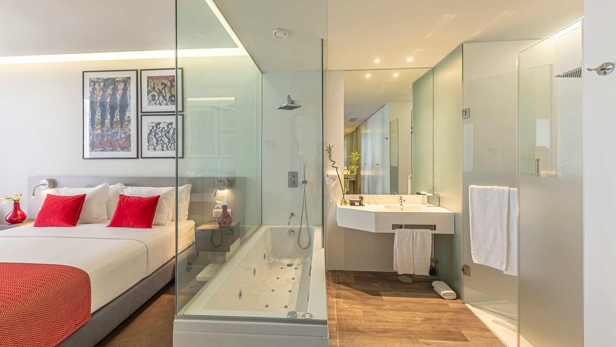 a bathroom with a glass shower and a bed