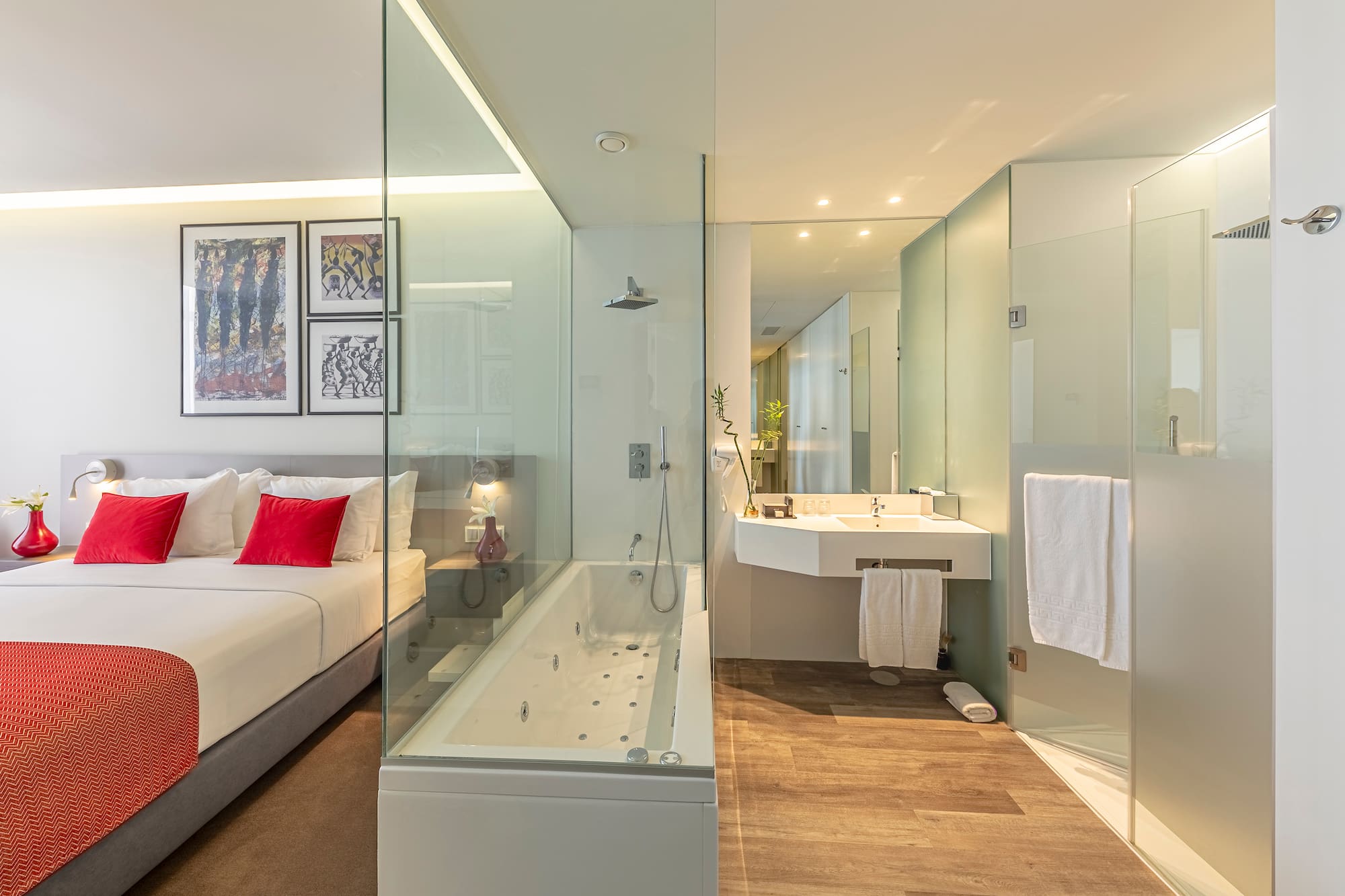 a bathroom with a glass shower and a bed