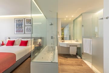 a bathroom with a glass shower and a bed