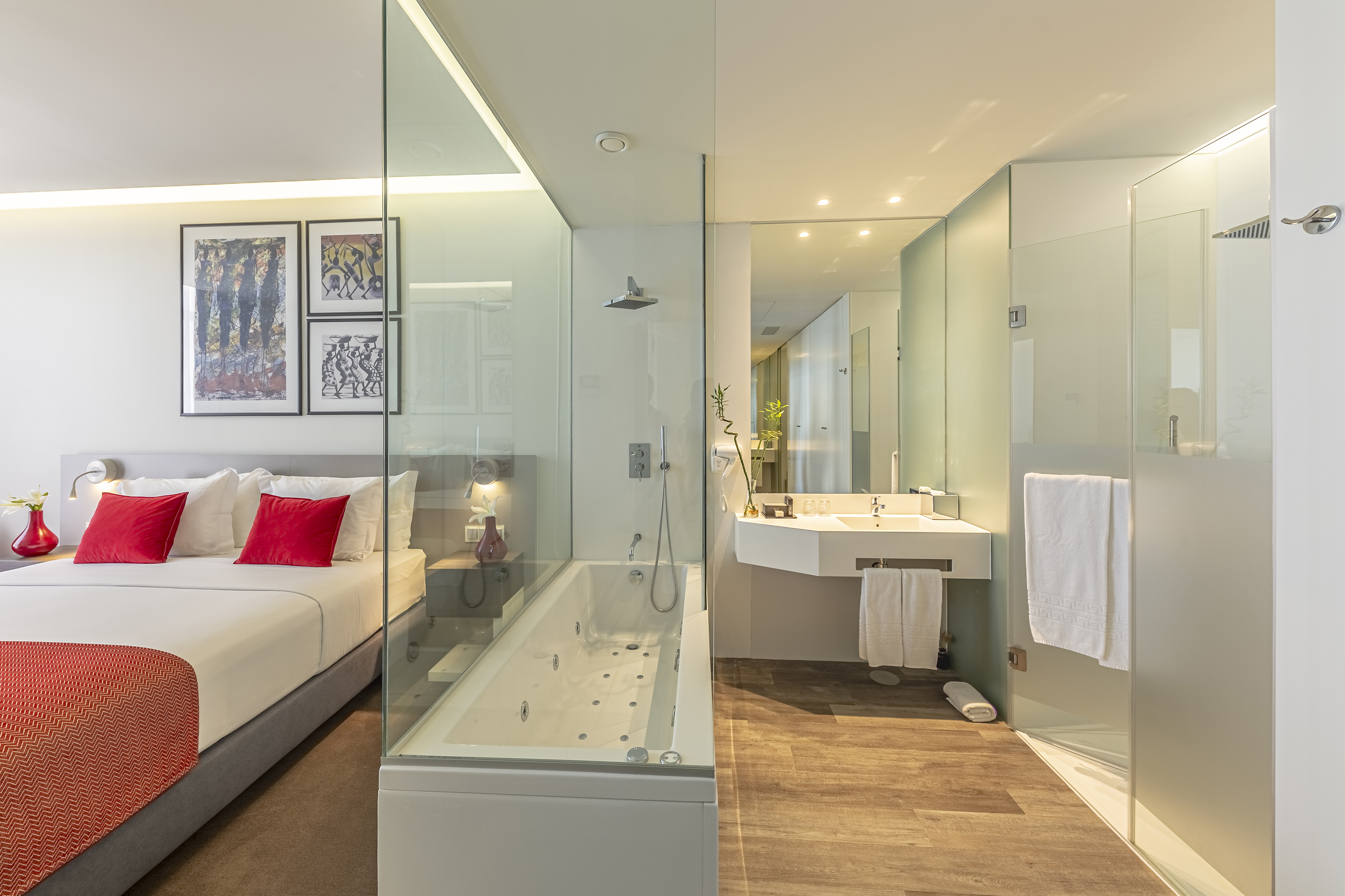 a bathroom with a glass shower and a bed
