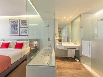a bathroom with a glass shower and a bed