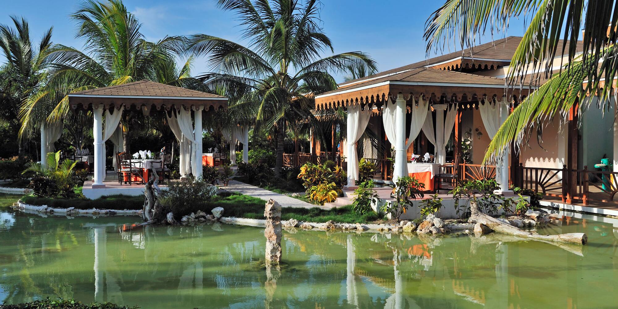 a building with a pond and palm trees